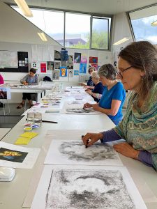 people sitting painting and drawing at a table