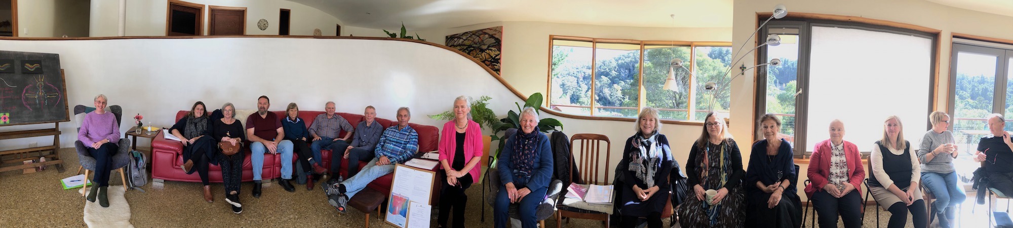 a group of smiling people sitting in a long row