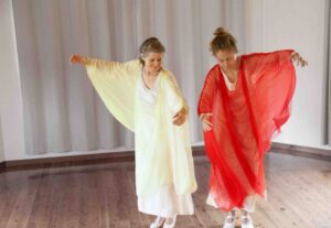 Two people dressed in long veils performing eurythmy