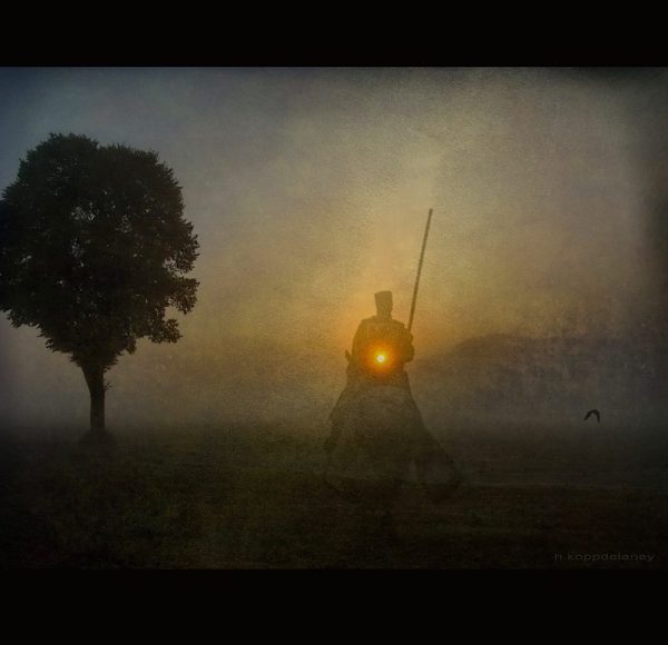 ghostly figure of a knight on a horse at last light of day, near a silhouetted tree